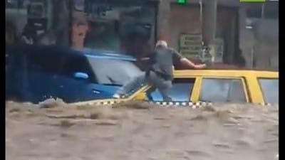 Taxi driver climbs out as rushing flood waters fill car cabin - El Salvador - Watch